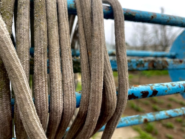 A blue metal fence has a bunch of rope on it.