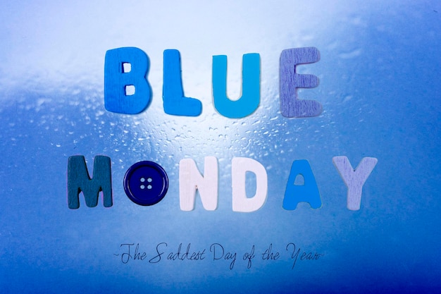 Концепция Blue Monday Буквы и кнопка на дождливом синем фоне