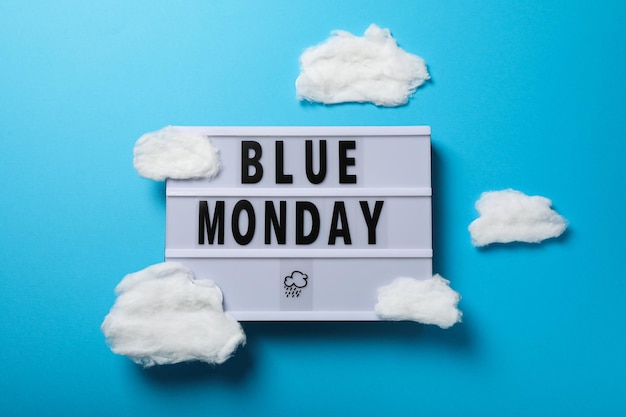 Photo blue monday text and clouds on blue background top view