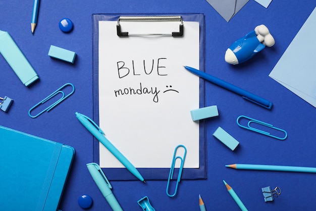 Blue Monday text and stationery on blue background top view