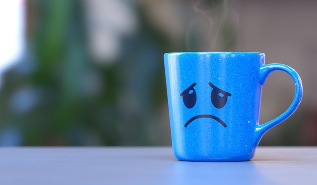 a blue mug with a sad face on a home scene symbolizing the blue monday mood or emotional sadness