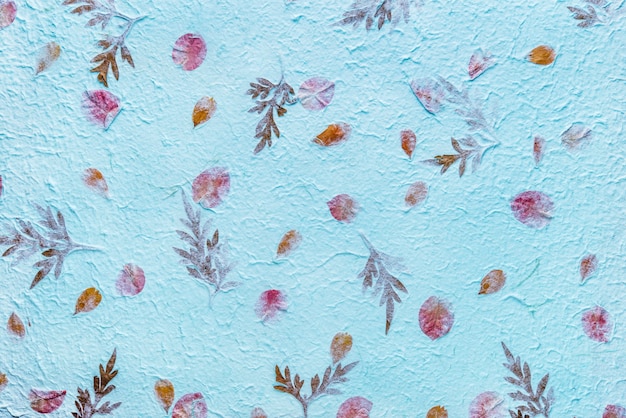 Blue mulberry paper with the texture of flowers and foliage is used as a background.