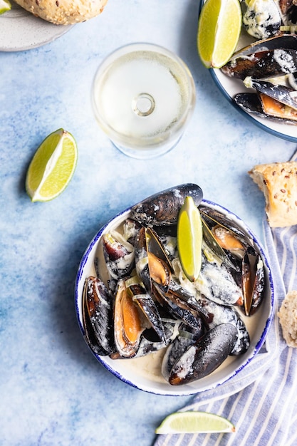 Foto cozze blu in salsa di vino bianco con lime e pane spezzatino di cozze in salsa di vino, porro e formaggio erborinato