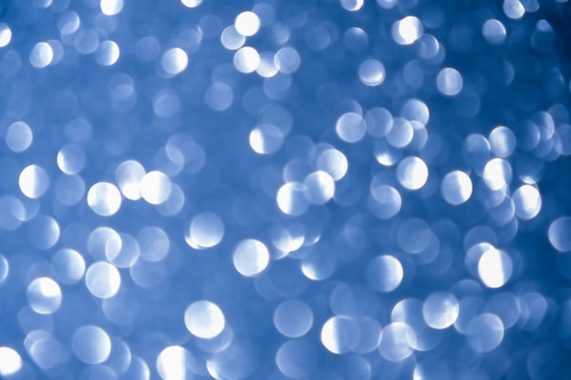 ブルーネイビーの背景キラキラシルバークリスマステクスチャ抽象的なボケ味の光輝く星。キラキラビンテージライト背景