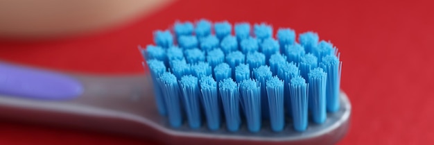 Blue new toothbrush on red background. Correct oral care