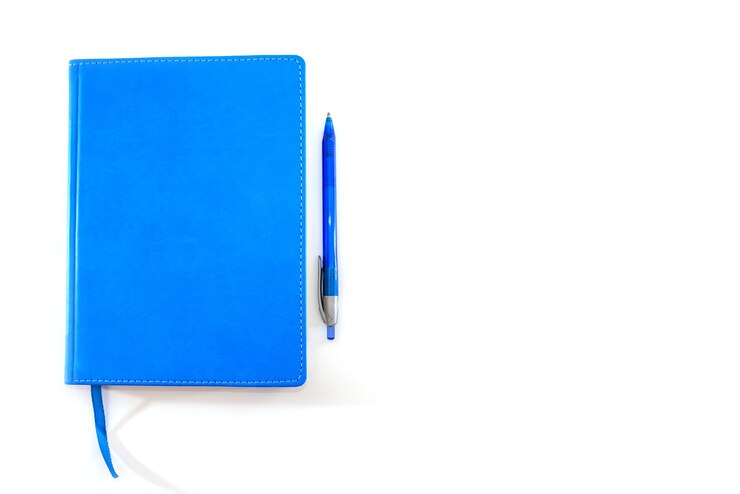 Photo blue notepad and blue pen on a white background. copy space.