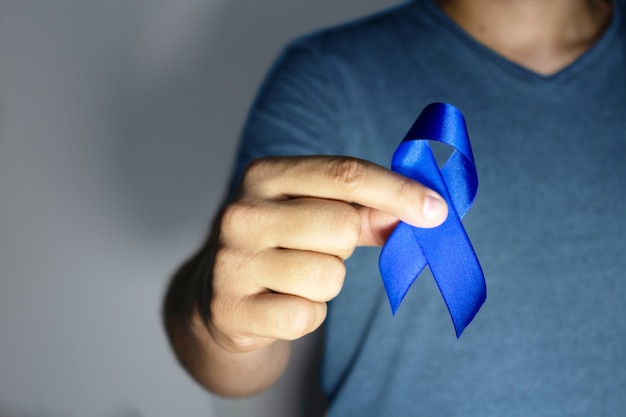 Photo blue november  man holding blue ribbon