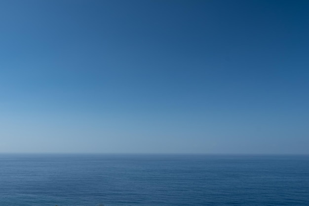 空白がたくさんある青い海または海の背景、穏やかな水の上の青い空、波がなく、滑らかな表面、ミニマルな風景、マリンビュー、夏の自然の壁紙、休暇の写真