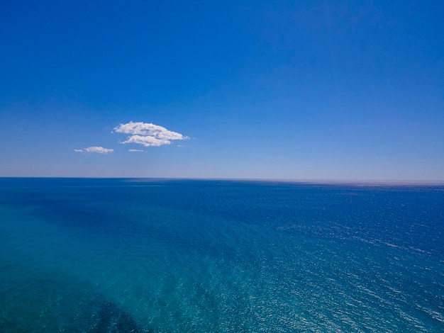 A blue ocean with a cloud in the sky