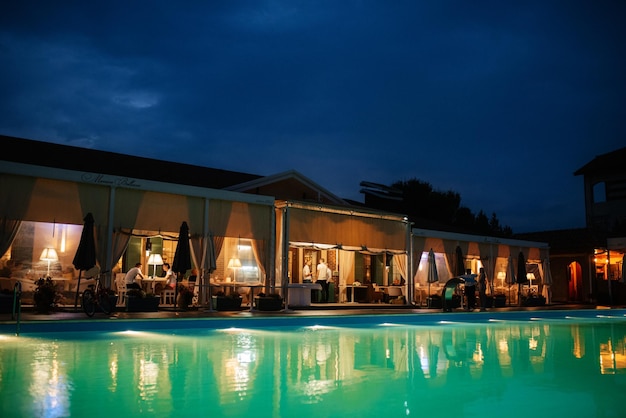 Blue outdoor pool in the garden surrounded by coniferous trees