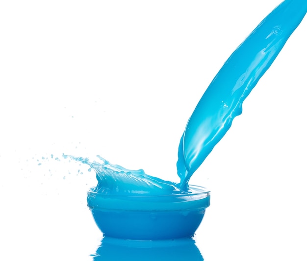 Foto vernice blu fuoriuscita d'acqua spruzzo in tazza tazza lozione liquida blu idratante cosmetici versare galleggiare in mezzo all'aria bevanda cocktail blu esplosione lancio svolazzante sfondo bianco serie isolata due di immagini