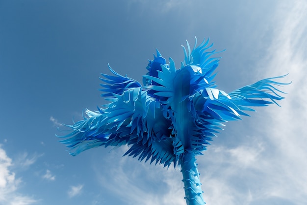 Blue palm tree against blue sky background