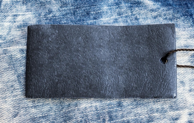 Blue paper label on the light blue jeans texture Close up