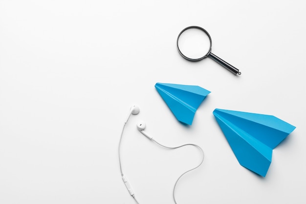 Blue paper plane with magnifying glass