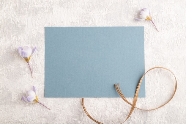 blue paper sheet with spring snowdrop crocus flowers