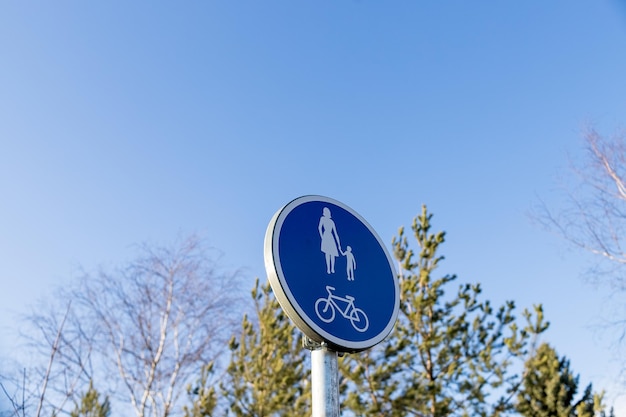 Blue pedestrian crossing and bicycle lane street sign Bike path and walkway for walkers Infrastructure for walking and physical activity in the park