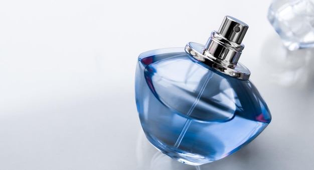 光沢のある背景に青い香水瓶甘い花の香り魅力的な香りとホリデー ギフトと高級美容化粧品ブランド デザインとしてオード パルファム