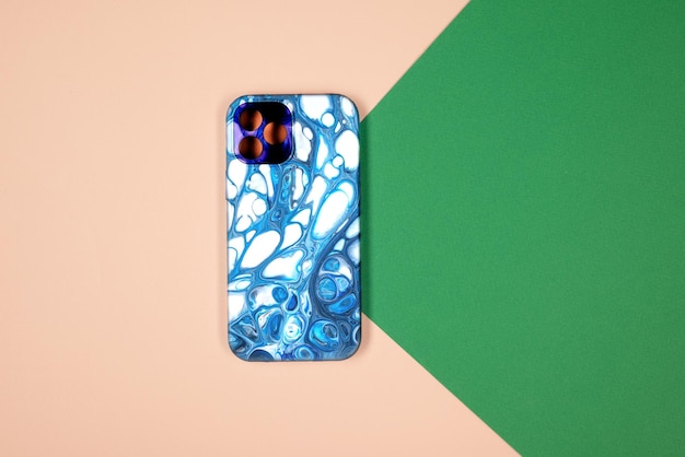 Vista posteriore della cassa del telefono blu. modello di custodia per iphone 12 plus. sfondo verde e beige
