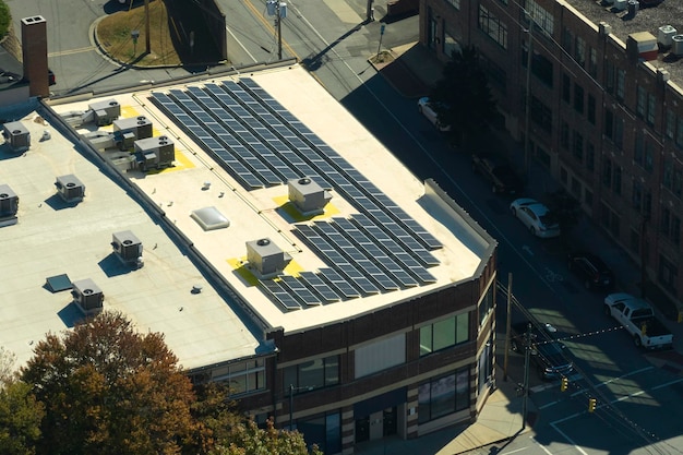 住宅の建物の屋根に取り付けられた青い太陽光発電パネルは、クリーンで生態学的な電力を生成します再生可能エネルギーの概念の生成