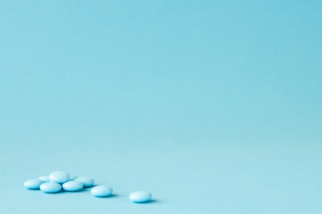 Blue pills on blue background with copy space