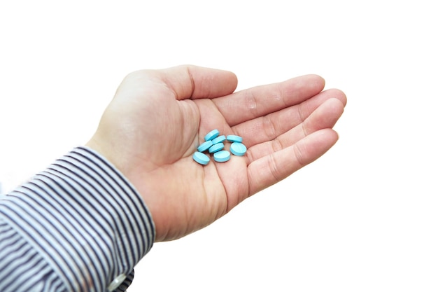 Blue Pills medical tables in man hand hold isolated on white