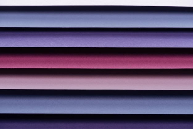 Blue pink burgundy and purple sheets of paper with copy space