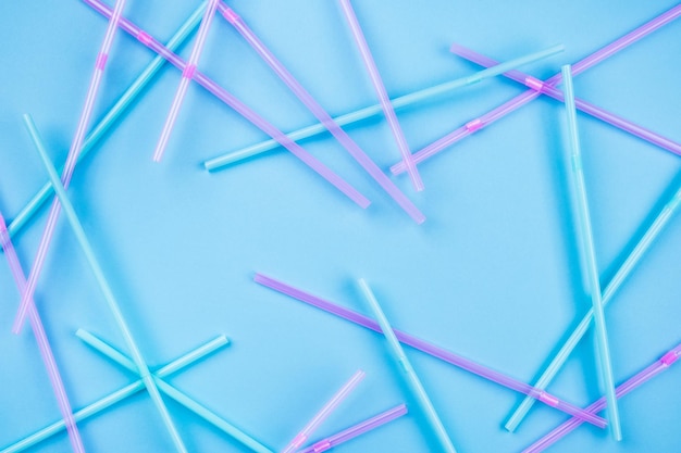 Blue and pink cocktail straws on a color background