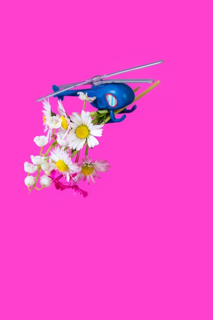 ブルーピンクパープルペーパーボックスギフトおもちゃ配達ヘリコプター花背景