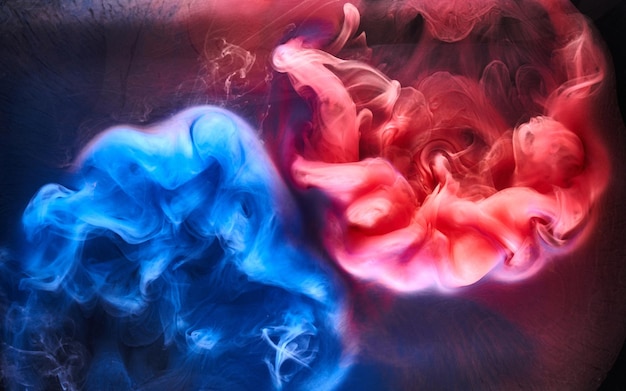 Photo blue pink smoke on black ink background, colorful fog, abstract swirling ocean sea, acrylic paint pigment underwater