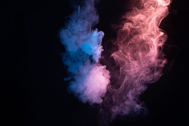 Blue and pink steam on a black background. Copy space.