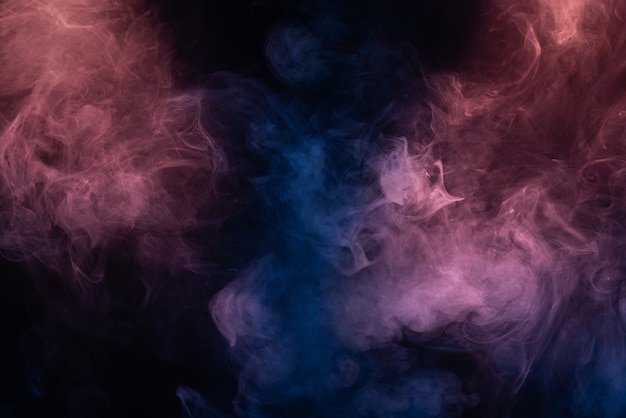 Blue and pink steam on a black background. Copy space.