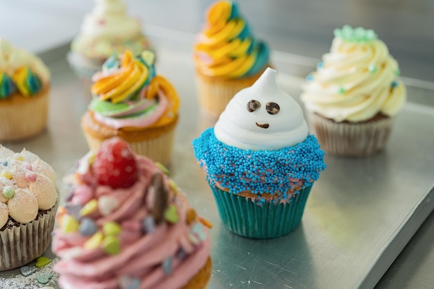 Blue, pink and white cup cake on a blue background for birthday or halloween in confectionery