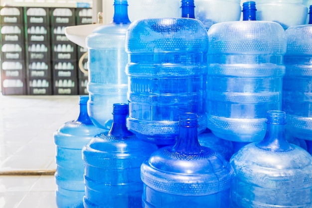 Blue plastic bottles or blue gallons of drinking water are stacked in the drinking water factory