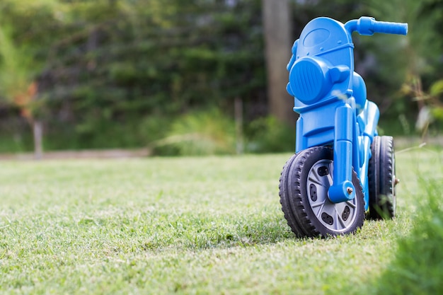 庭で青いプラスチック子供三輪車