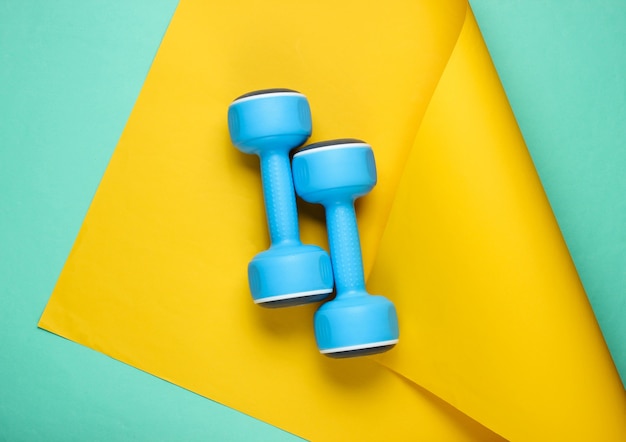 Photo blue plastic dumbbells on wrapped paper