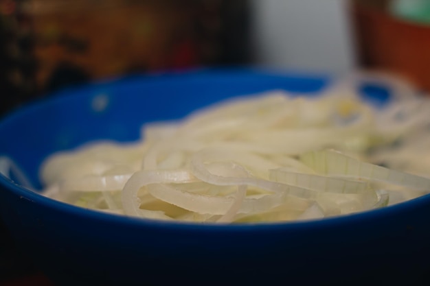 Foto piatto blu pieno di grande cipolla in cucina per preparare un delizioso tamale colombiano