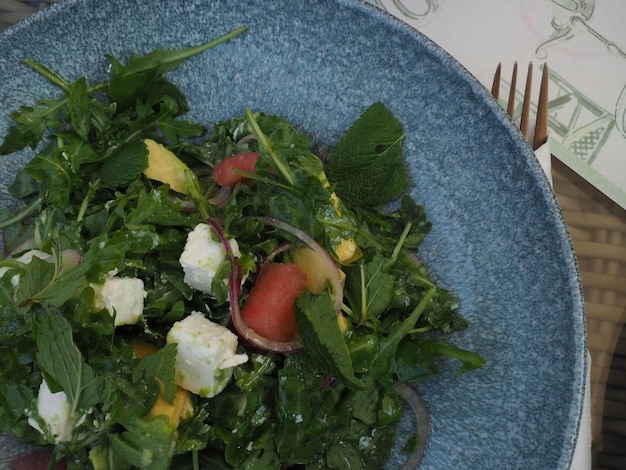 A blue plate with a salad on it