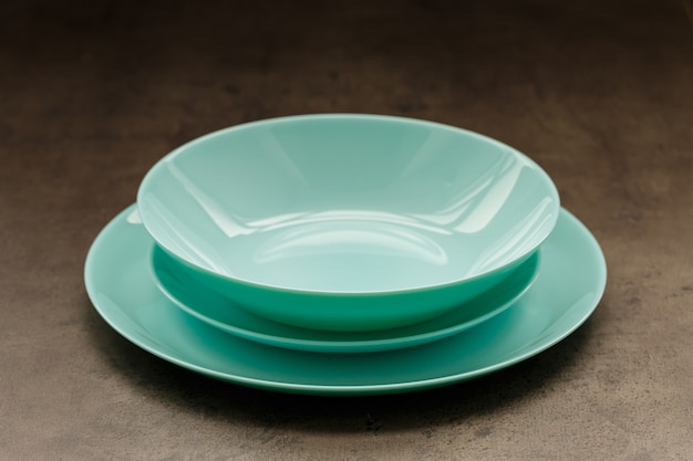 Blue plates of different sizes and shapes on a gray background