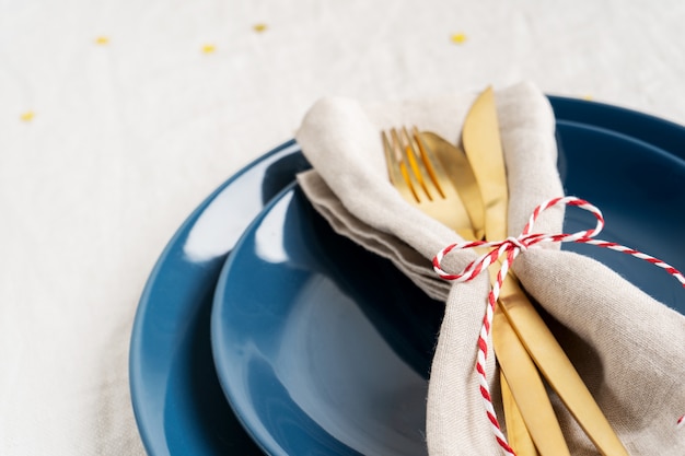 Blue plates and golden cutlery in a napkin