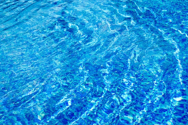 Acqua blu della piscina con riflessi del sole