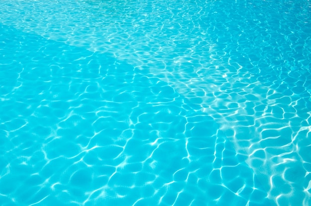 Acqua blu della piscina con riflessi del sole