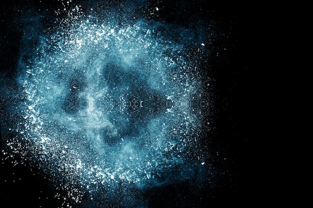 Photo blue powder explosion on black background.