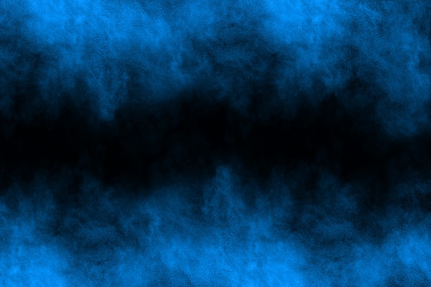 Photo blue powder explosion on black background.