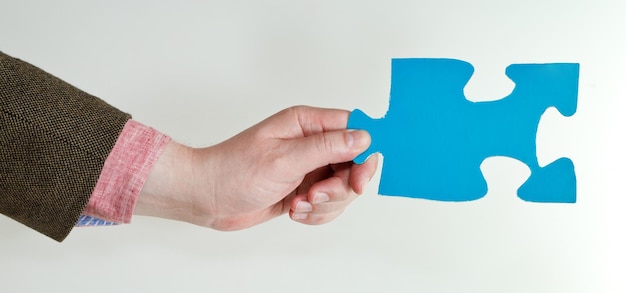 Photo blue puzzle piece in male hand