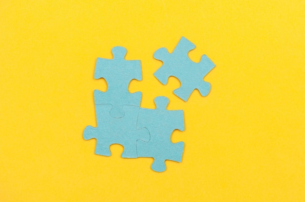 Blue puzzle pieces with a missing piece on a yellow background