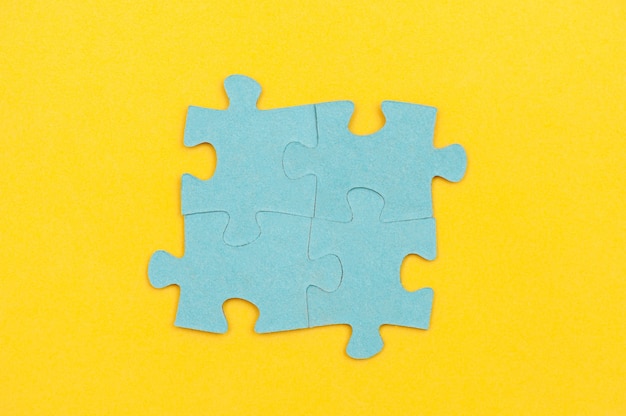 Photo blue puzzle pieces on a yellow background business concept