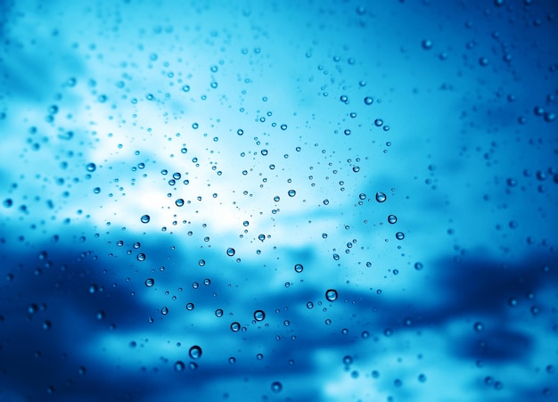 Blue rain drops on window glass background hd