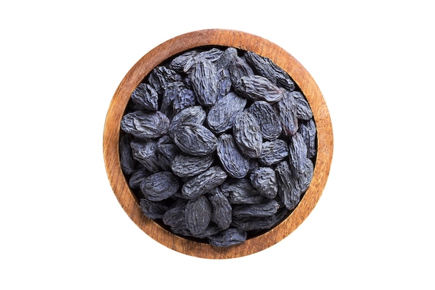 Blue raisins dried grapes in wooden bowl isolated on white background Vegan food top view