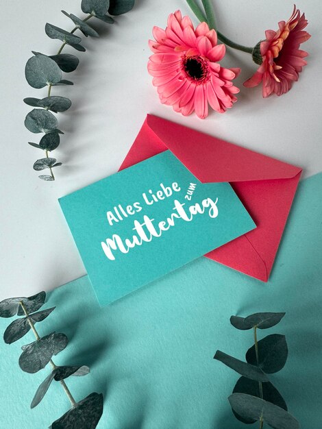 Photo blue red envelopes and gerbera flowers text alles liebe zum muttertag means all love on mothers day