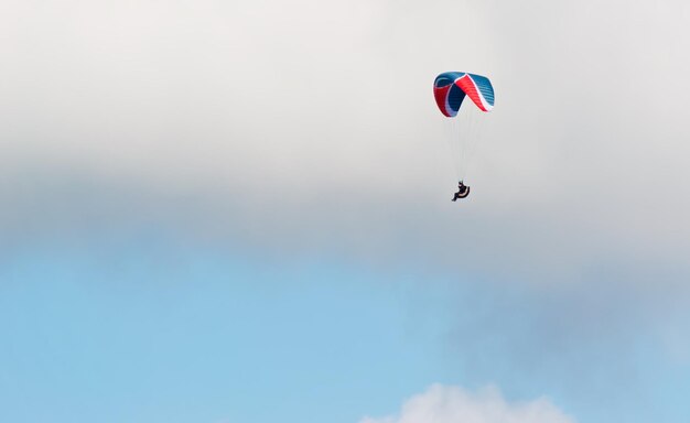 Blue and red glider in a cloudy day